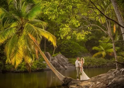 Jennifer Daniel holding each other and posing near coconut tree
